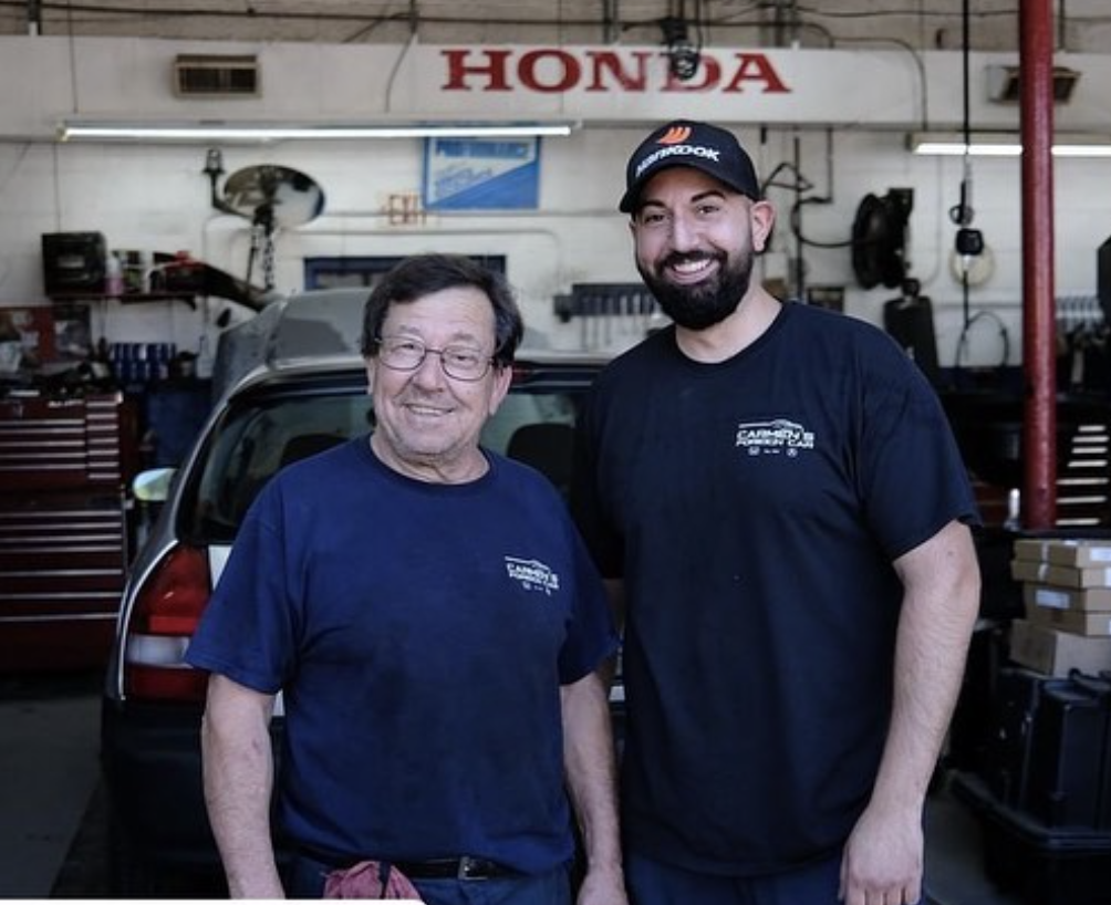 Carmen and Mike Finocchiaro together under the Honda sign in the Cranford shop